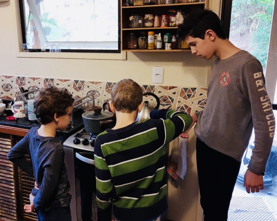 Artur, Miguel e Mateus, filhos de Liandra, em ação na cozinha de casa.